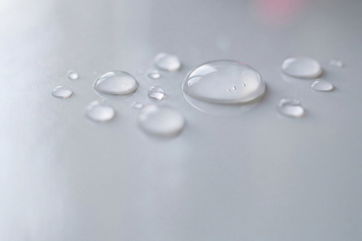 Klare Wassertropfen auf hellem Grund